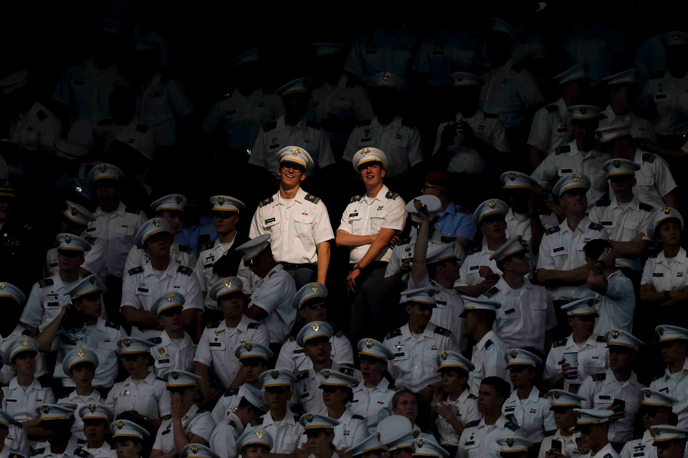 A shed of light falls on the Army cadets during the second half of an NCAA football game...