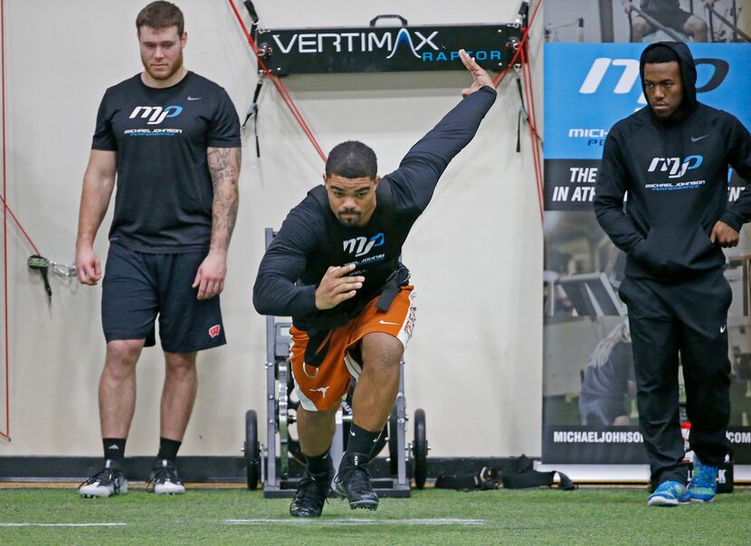 Chris Warren III, center, works out during an annual media day at Michael Johnson...