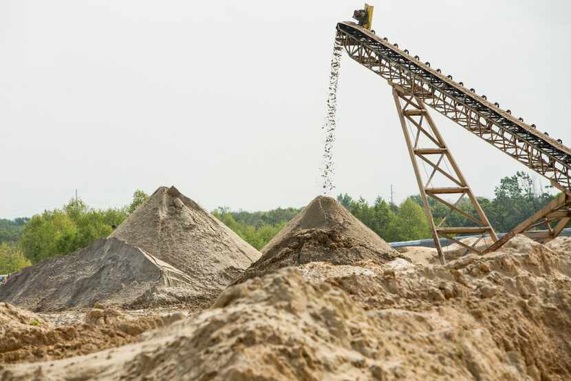 Sand is dropped off a conveyor onto a pile at the Superior Silica Sands sand mine in Kosse,...