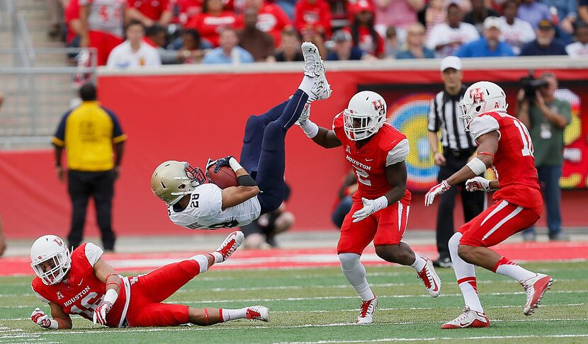 HOUSTON, TX - NOVEMBER 27:  Dishan Romine #28 of the Navy Midshipmen is upended by D'Juan...