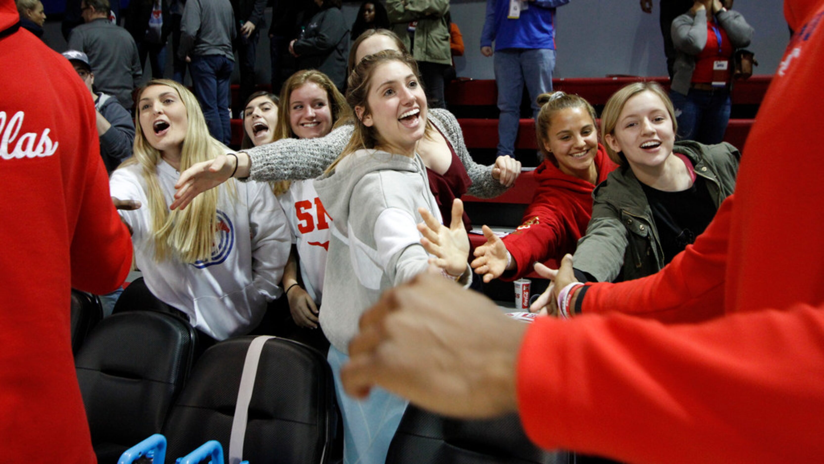 SMU players circle the court to greet fans to their delight following the Mustangs' 68-52...