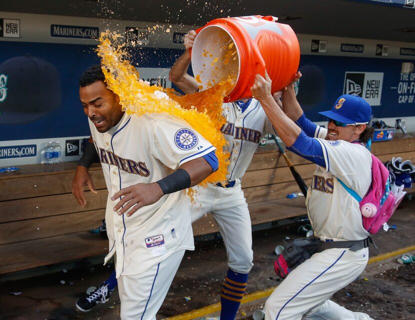 SEATTLE, WA - APRIL 19: Nelson Cruz #23 of the Seattle Mariners is doused by teammates Danny...