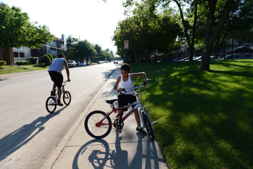 Keilob Blaylock, 10, rides his bike with his uncle along Timberglen Road in Dallas. The area...