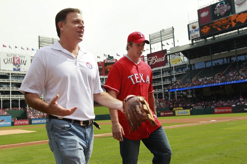 Texas Ranger owner Chuck Greenberg, left, walks off the field with Dallas Cowboy Sean Lee ...