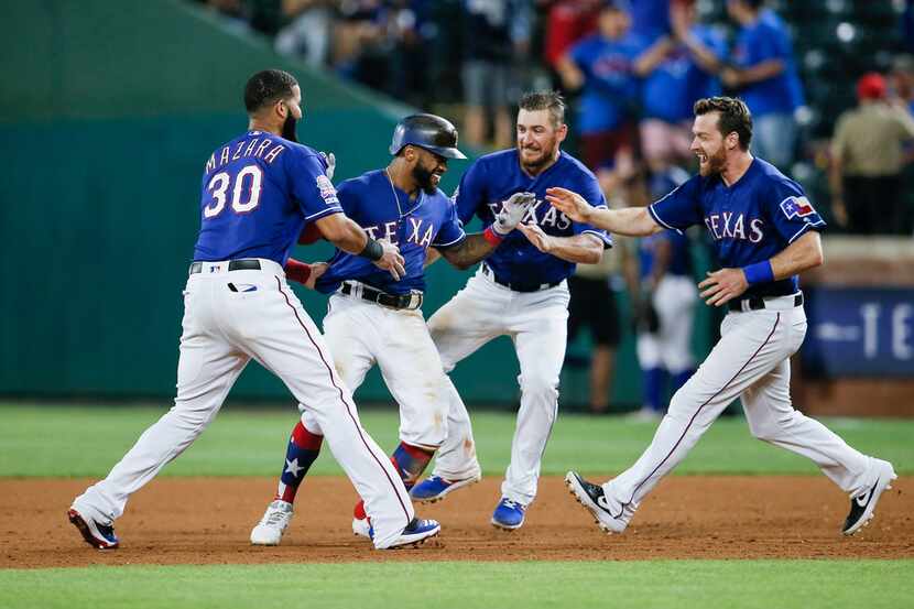 Texas Rangers' Delino DeShields, second from left, is congratulated by teammates after...