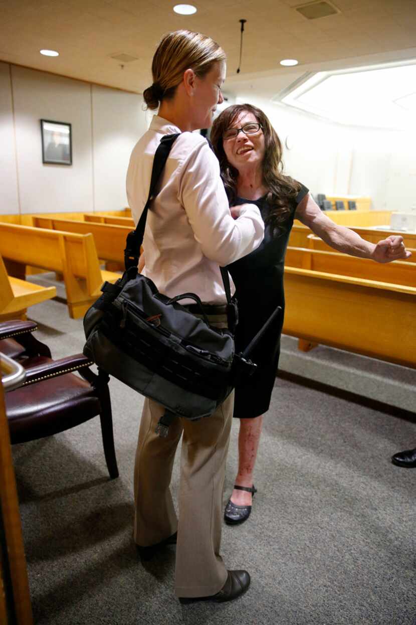 Burn victim Danyeil Townzen (right) got a hug from Dallas police Detective Gloria Doll at...