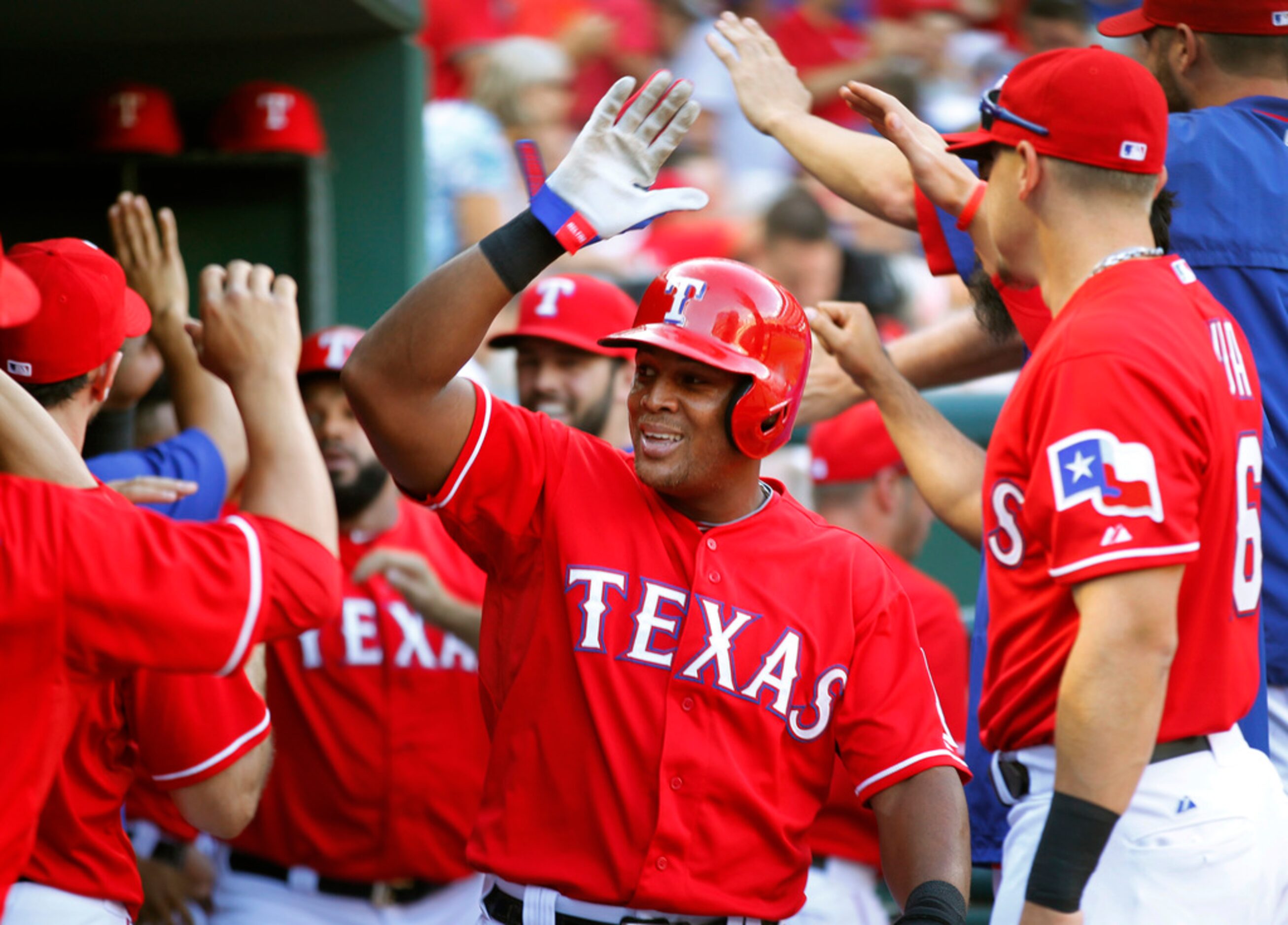 Texas Rangers third baseman Adrian Beltre (29) is congratulated in the dugout by teammates...