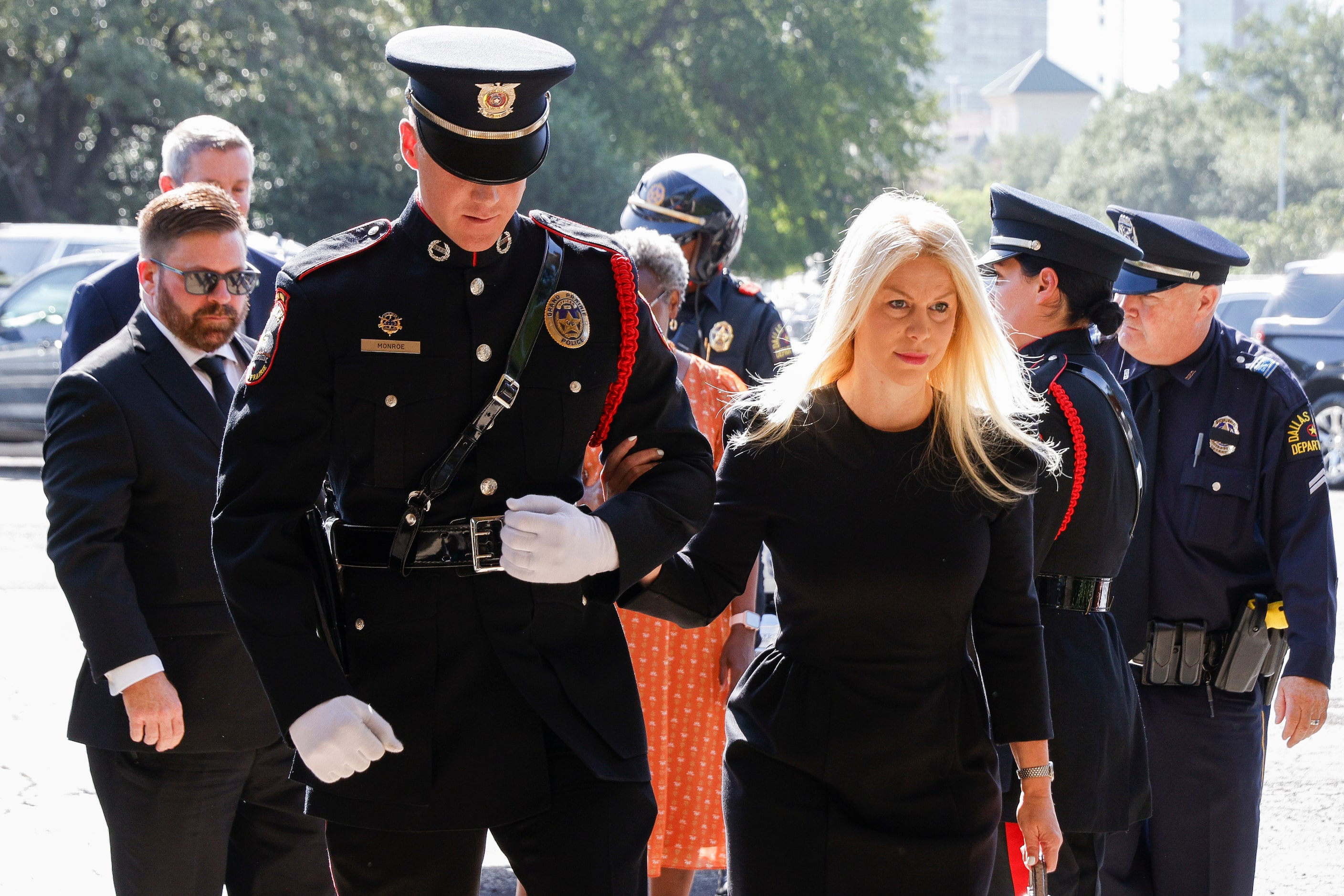 Sarah Dodd, David Kunkle’s wife, is escorted by a Grand Prairie police honor guard officer...