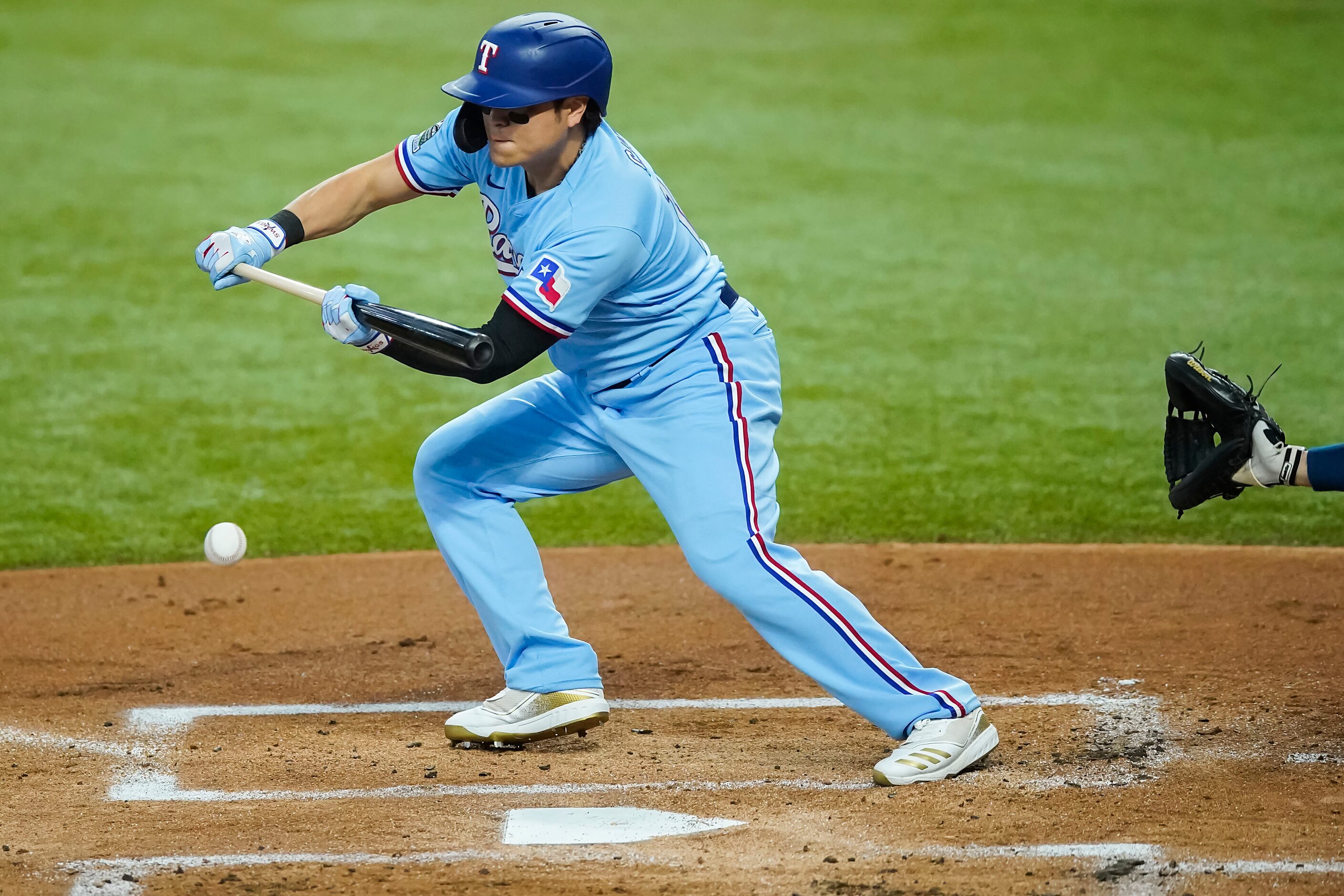 Texas Rangers designated hitter Shin-Soo Choo lays down a bunt for a lead-off single during...