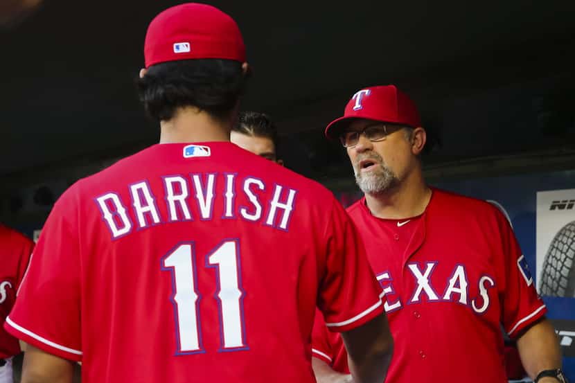 Texas Rangers starting pitcher Yu Darvish shakes hands with pitching coach Doug Brocail as...