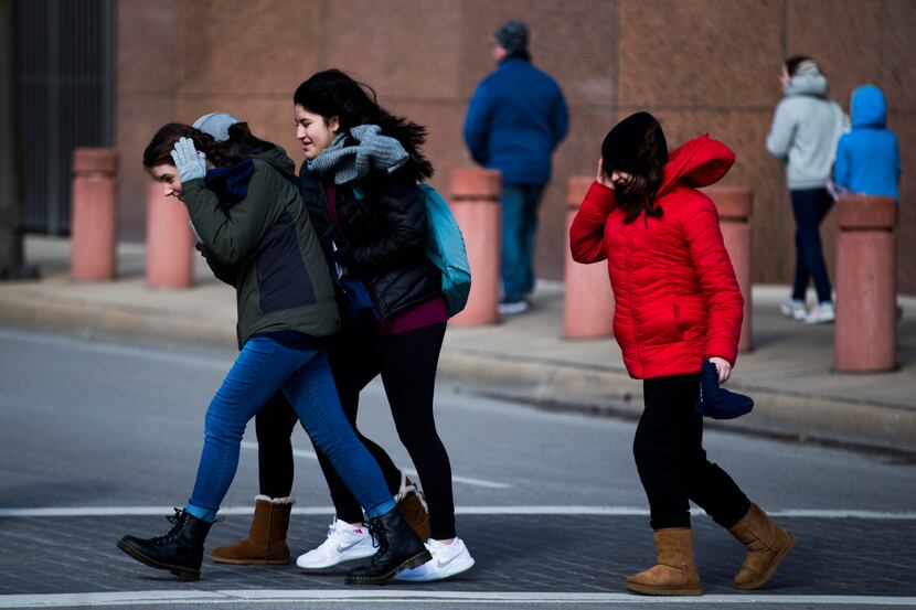 Girls walk into the the wind as they cross Griffin Street on Saturday, Jan. 19, 2019, in...