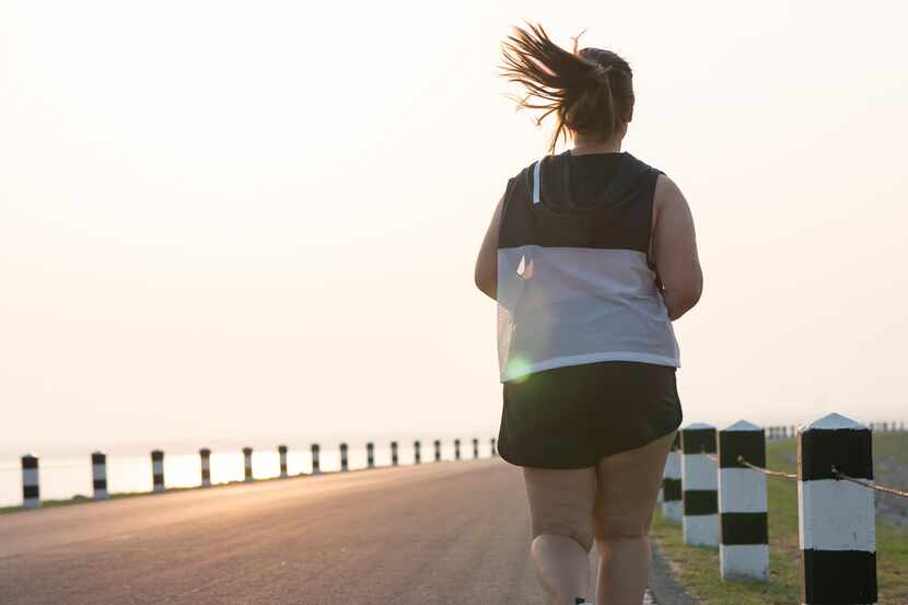 Foto de una mujer con sobrepeso corriendo.