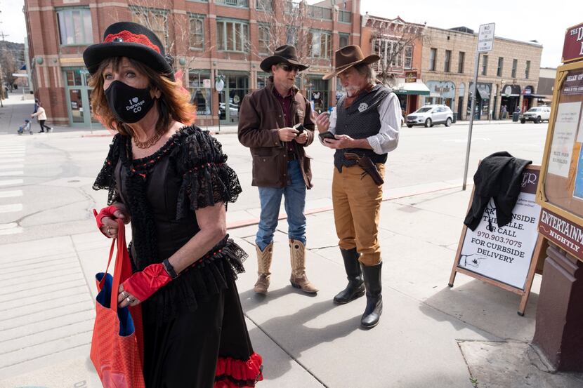 Dressed in Old West attire, Cathy Roberts (left) and Scott Perez (right) mix it up with...