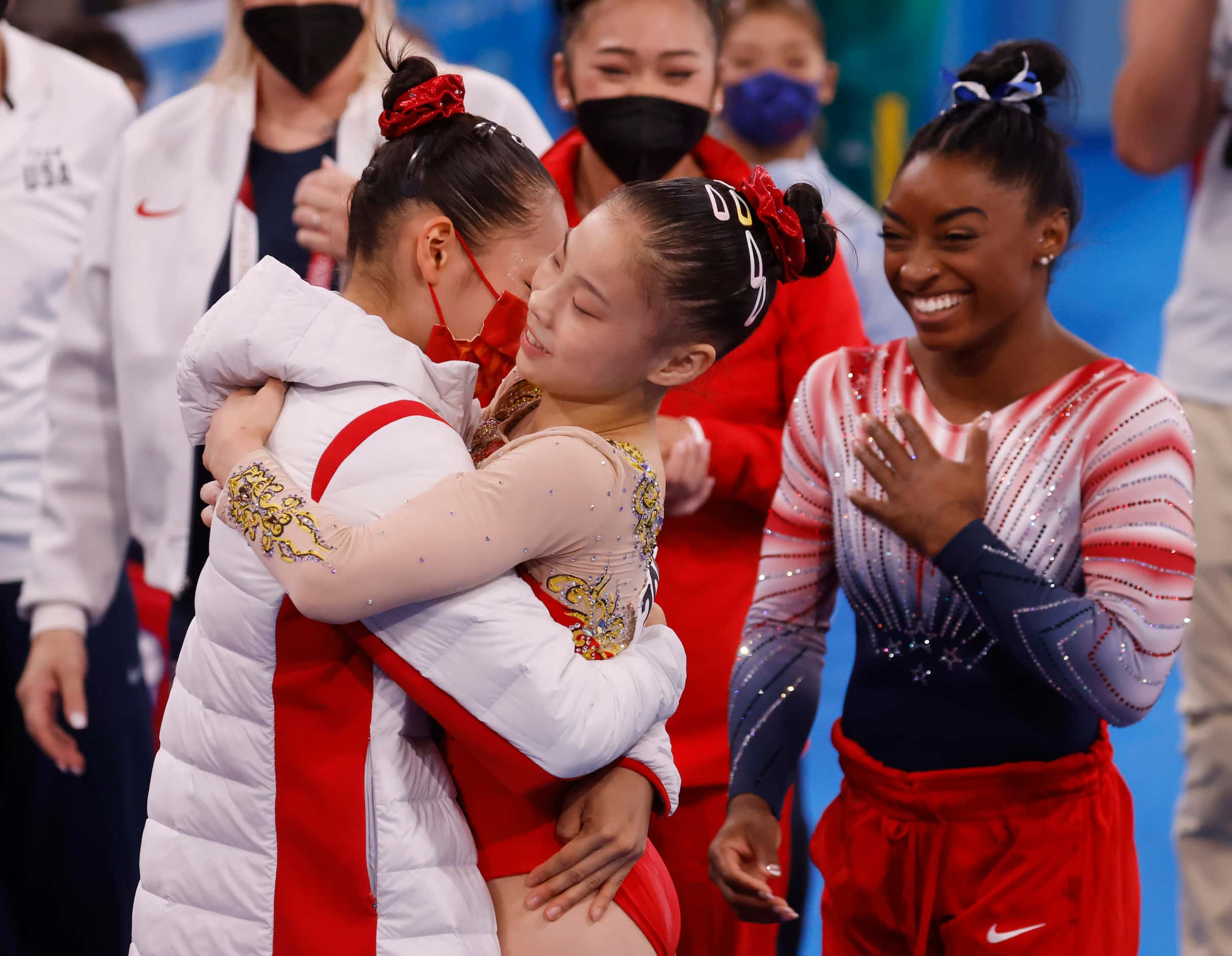 USA’s Simone Biles looks on as China’s Tang Xijing hugs teammate Guan Chenchen after she...