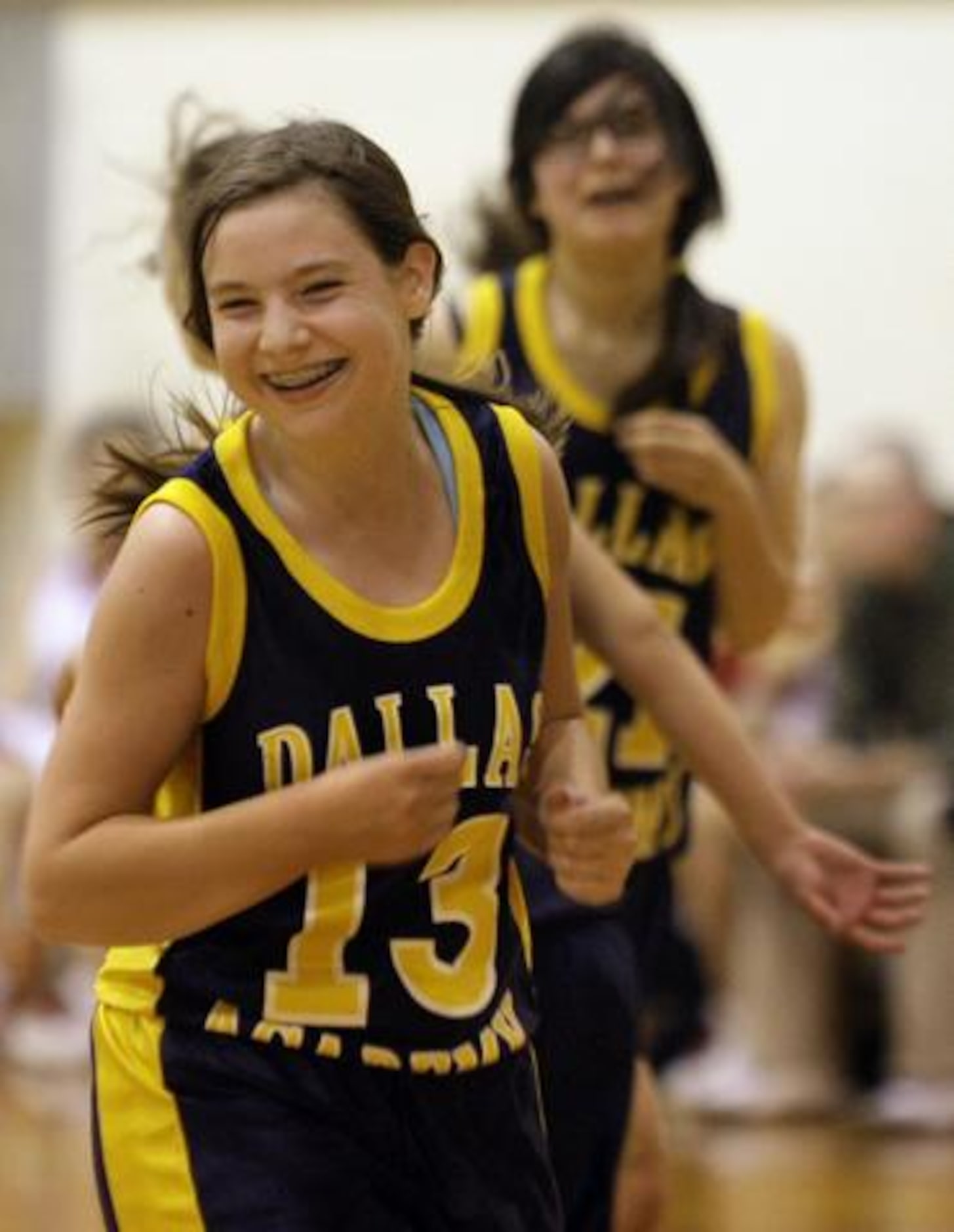 Dallas Academy's Shelby Hyatt (13) and teammate Teodora Palacios smile during a 32-10 loss...