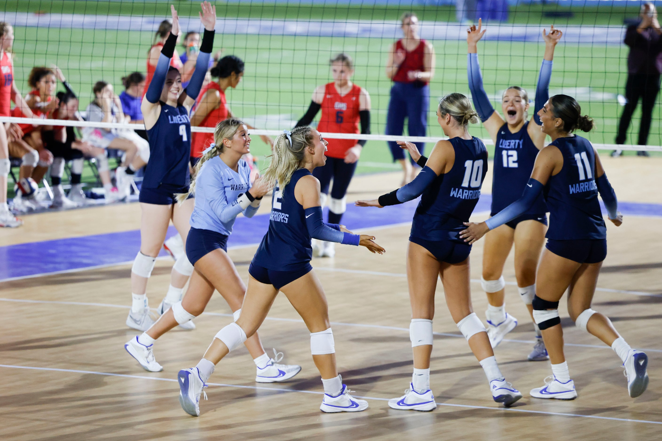 Liberty Christian School’ players celebrate a point during the first set of a volleyball...