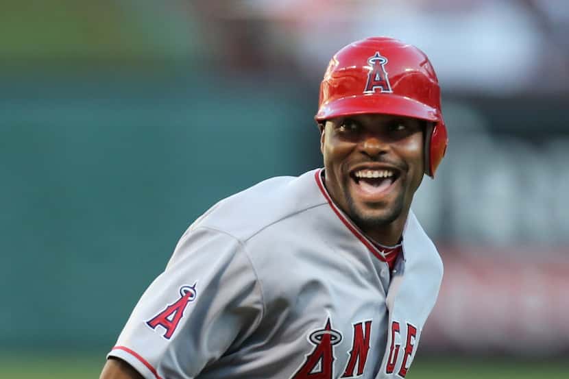 Angels' right fielder Torii Hunter laughs as he rounds third and scores on Mark Trumbo's...