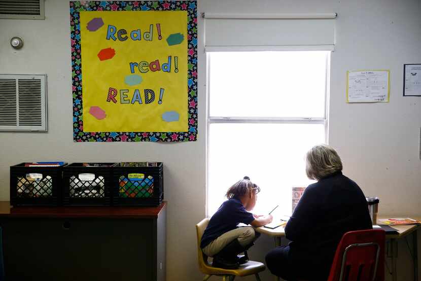 Beverly Funk, a First United Methodist Church of Dallas volunteer, helps a student learn to...