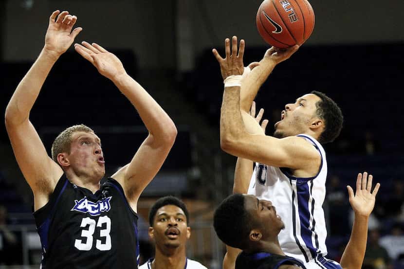 Abilene Christian Jacob Lancaster (33) tries to stop TCU's Kyan Anderson, right, during an...