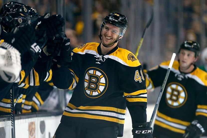 Boston Bruins' Colin Miller (48) celebrates his goal during the first period of an NHL...
