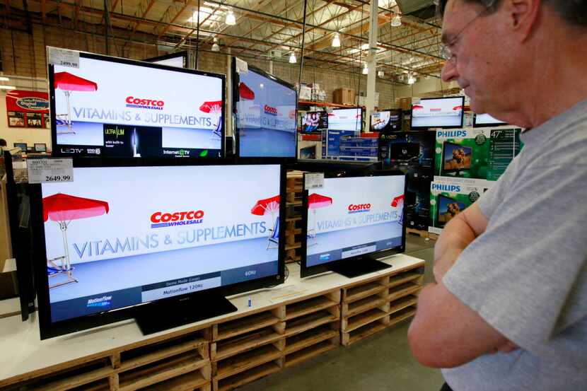 
In this May 4, 2010 photo, a customer looks at wide screen television sets at a Costco...