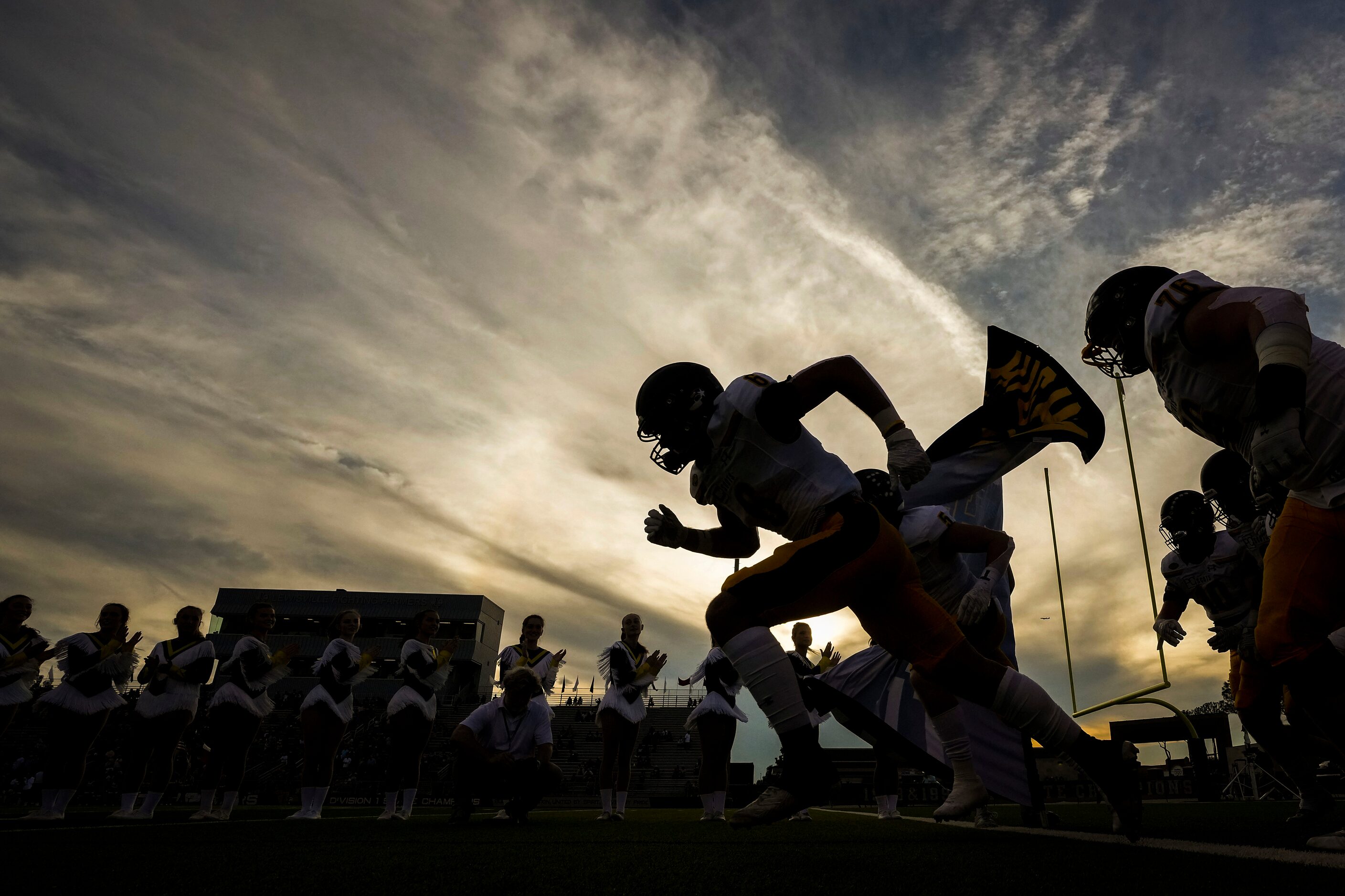 Highland Park players take the field before a high school football game against Lewisville...