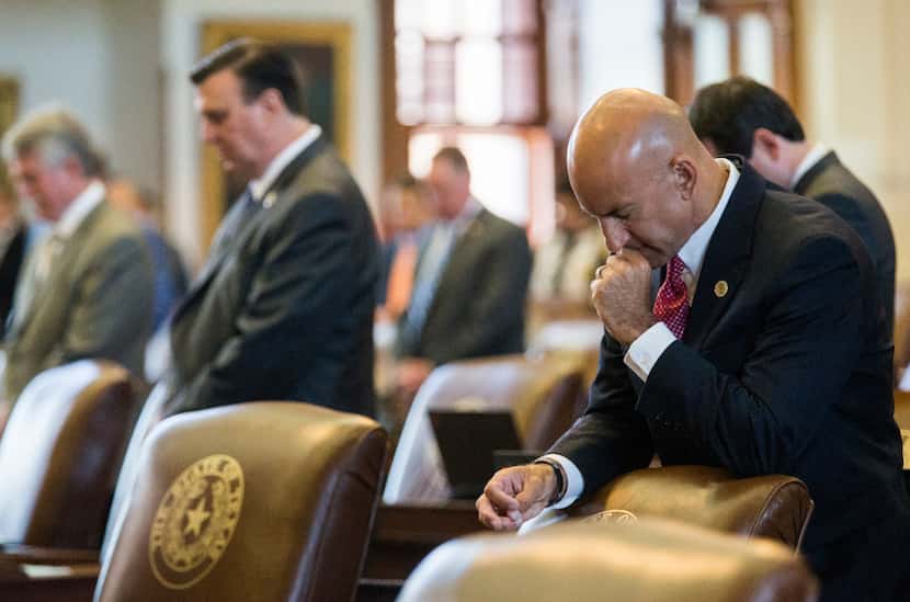 Representative Matt Shaheen of Plano and other representatives pray during the first day of...