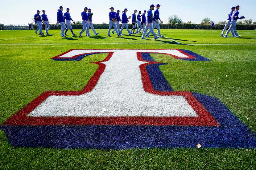 Texas Rangers players head to their first drills during the first spring training workout...