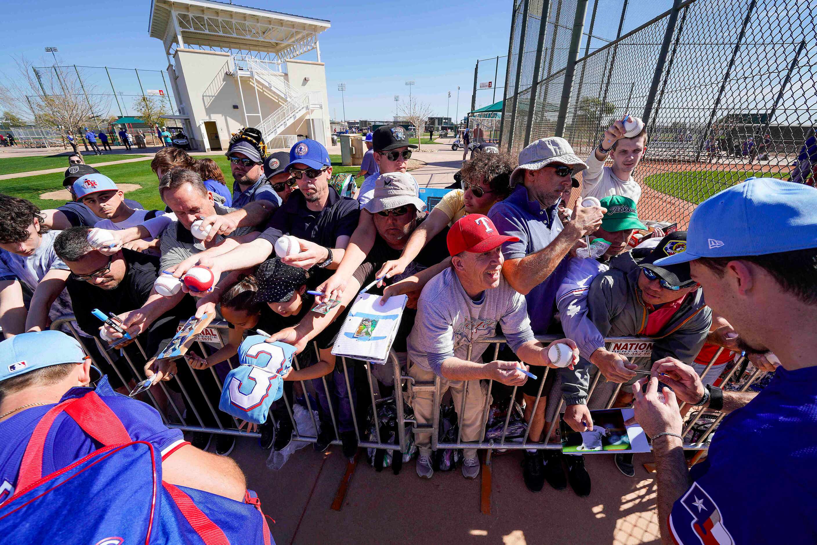 Texas Rangers outfielders Wyatt Langford (left) and Evan Carter sign autographs for fans...