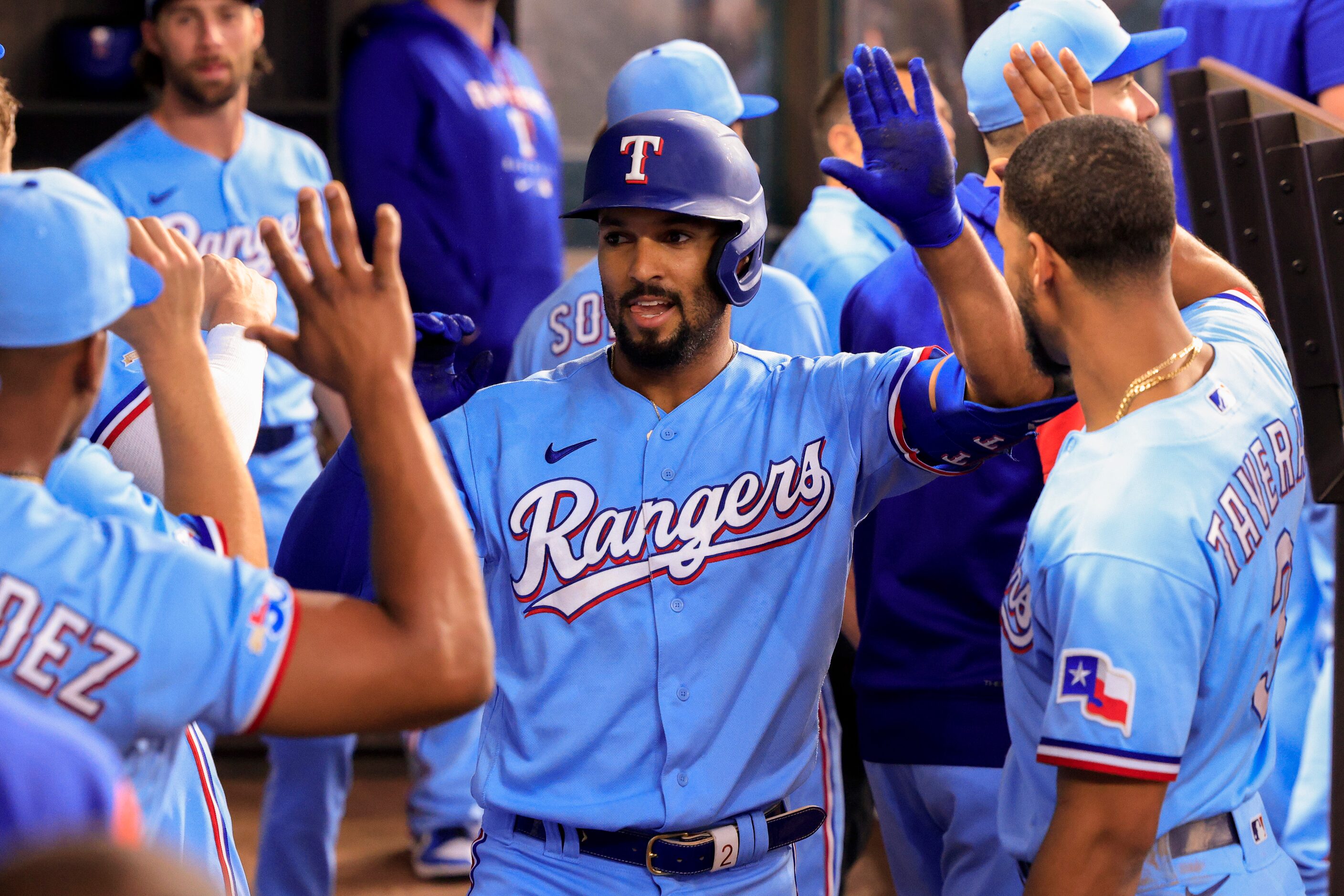 Texas Rangers second baseman Marcus Semien (2) high-fives teammates after hitting a home run...