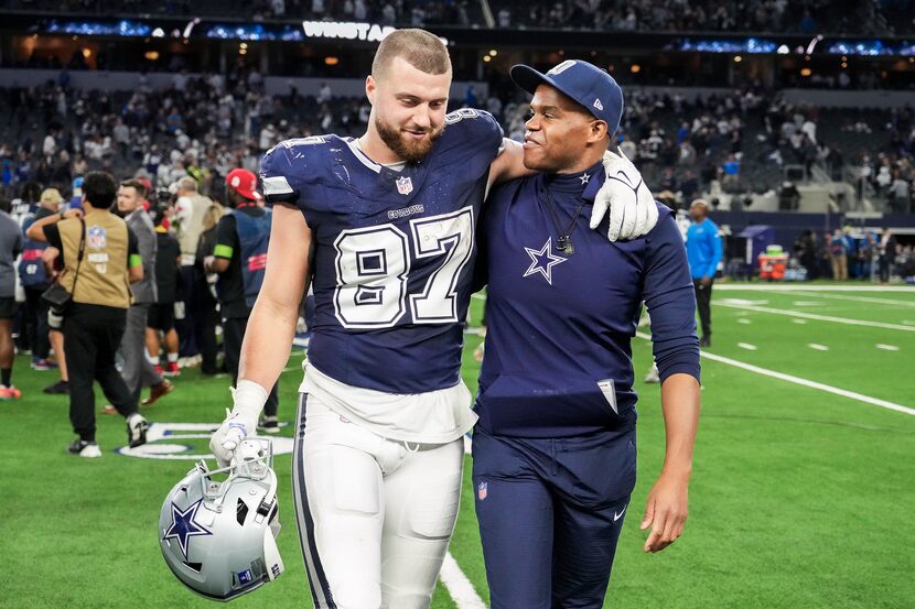 Dallas Cowboys tight end Jake Ferguson (87) walks off the field with tight ends coach Lunda...