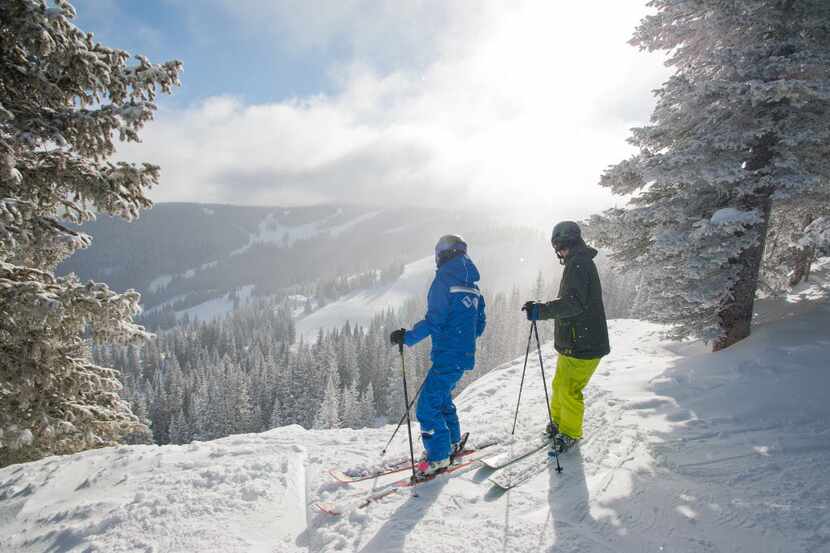 Skiers take a break to enjoy the view in Vail, Colo.