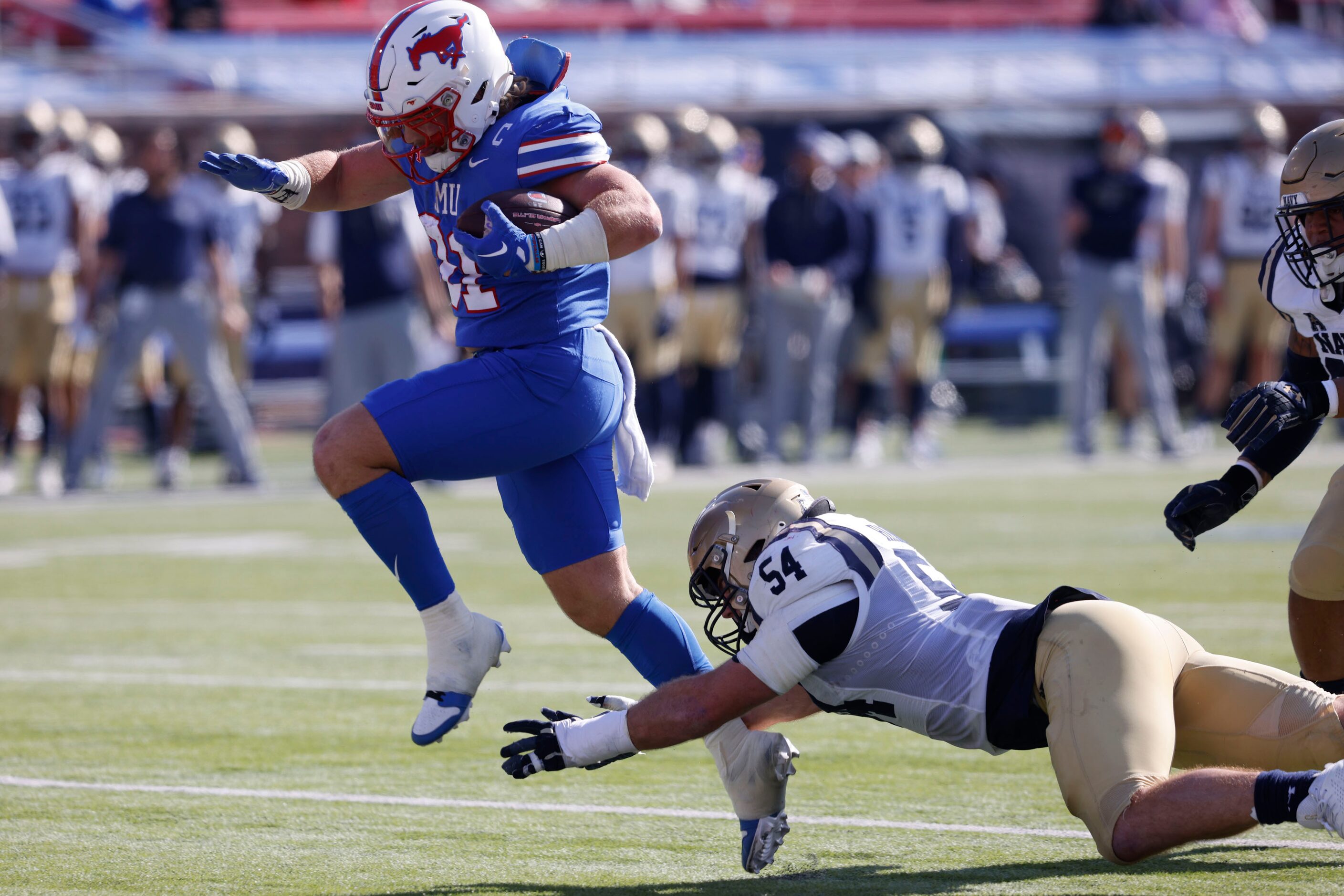 SMU running back Tyler Lavine (31) scores a touchdown over Navy linebacker Will Harbour (54)...