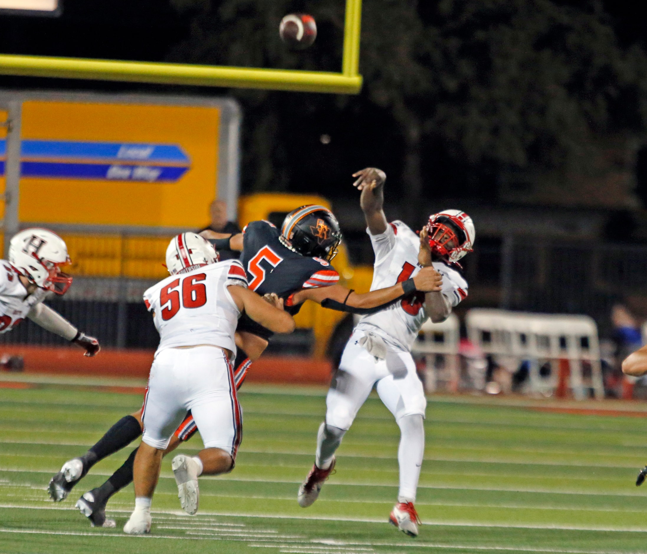 Rockwall Heath High QB Prosper Neal (16) throws under pressure by Rockwall High defender...