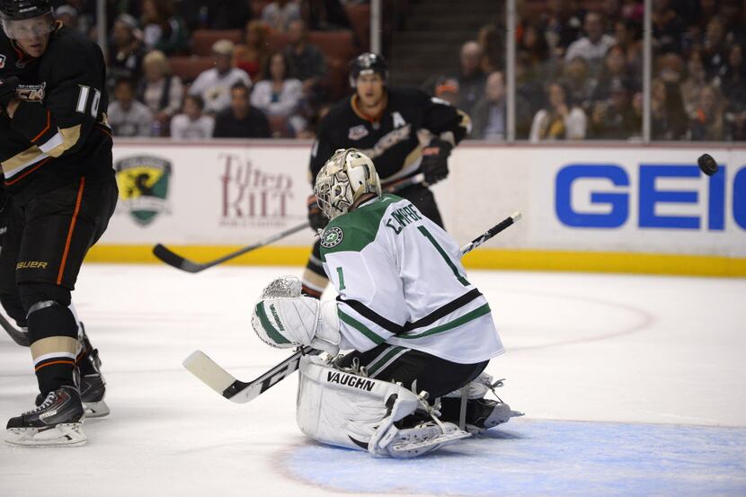 Anaheim Ducks right wing Corey Perry, left, deflects a shot by Dallas Stars goalie Jack...