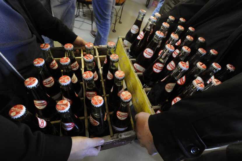 Michael Sparks, left, and Zach Hughes of Granbury, hold the 10-ounce bottles of Dublin Dr...