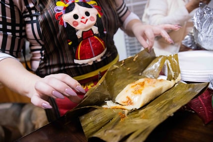 Sara Klein, the hostess behind the evening’s “tamalada,” unwraps a tamale cooked in a banana...