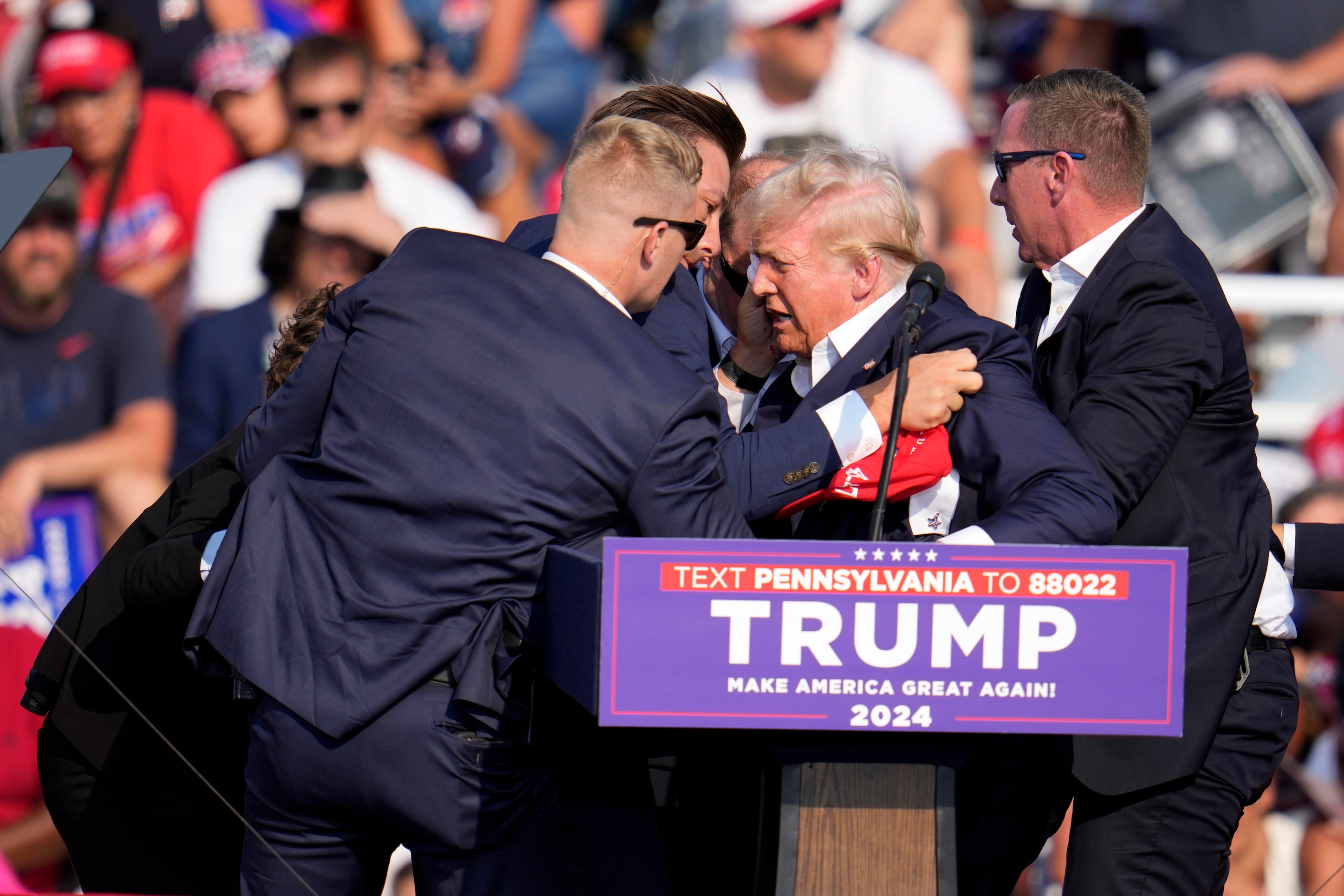 Republican presidential candidate former President Donald Trump is helped off the stage at a...