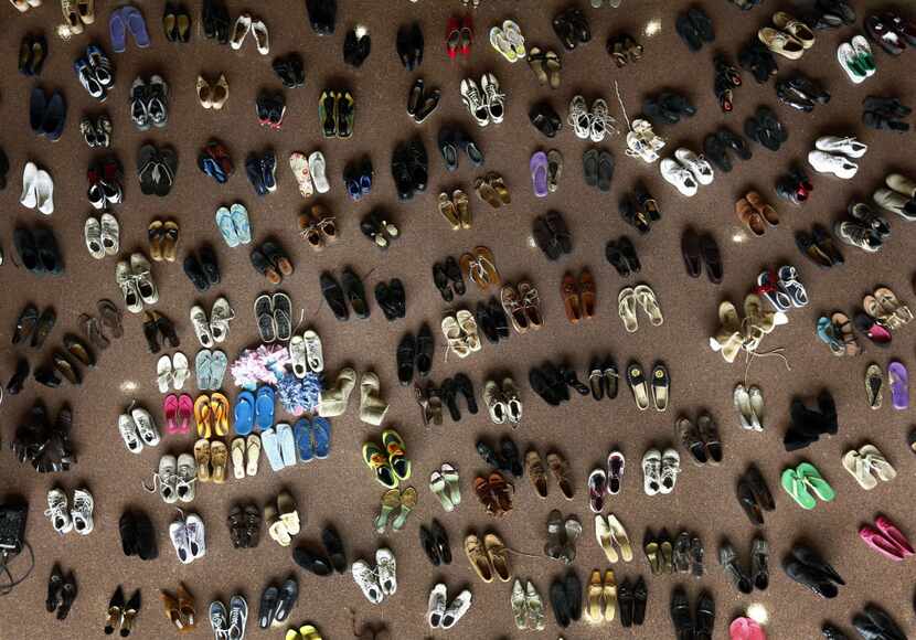 In this file photo, pairs of shoes representing those lost to suicide fill the floor of...