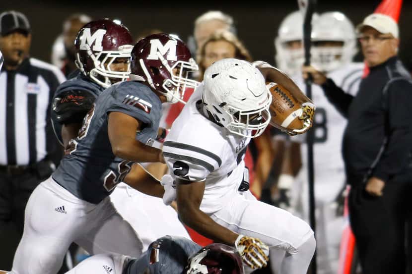 Rockwall Heath running back Tanner McCalister (2) is tackled by Mesquite defenders Kadarryus...