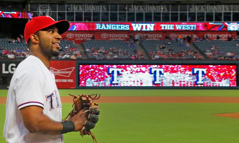 Texas Rangers shortstop Elvis Andrus (1) warms up before the game as the scoreboard...