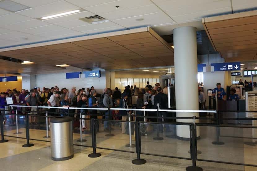  Travelers stacked up at a security checkpoint at Dallas/Fort Worth International Airport in...