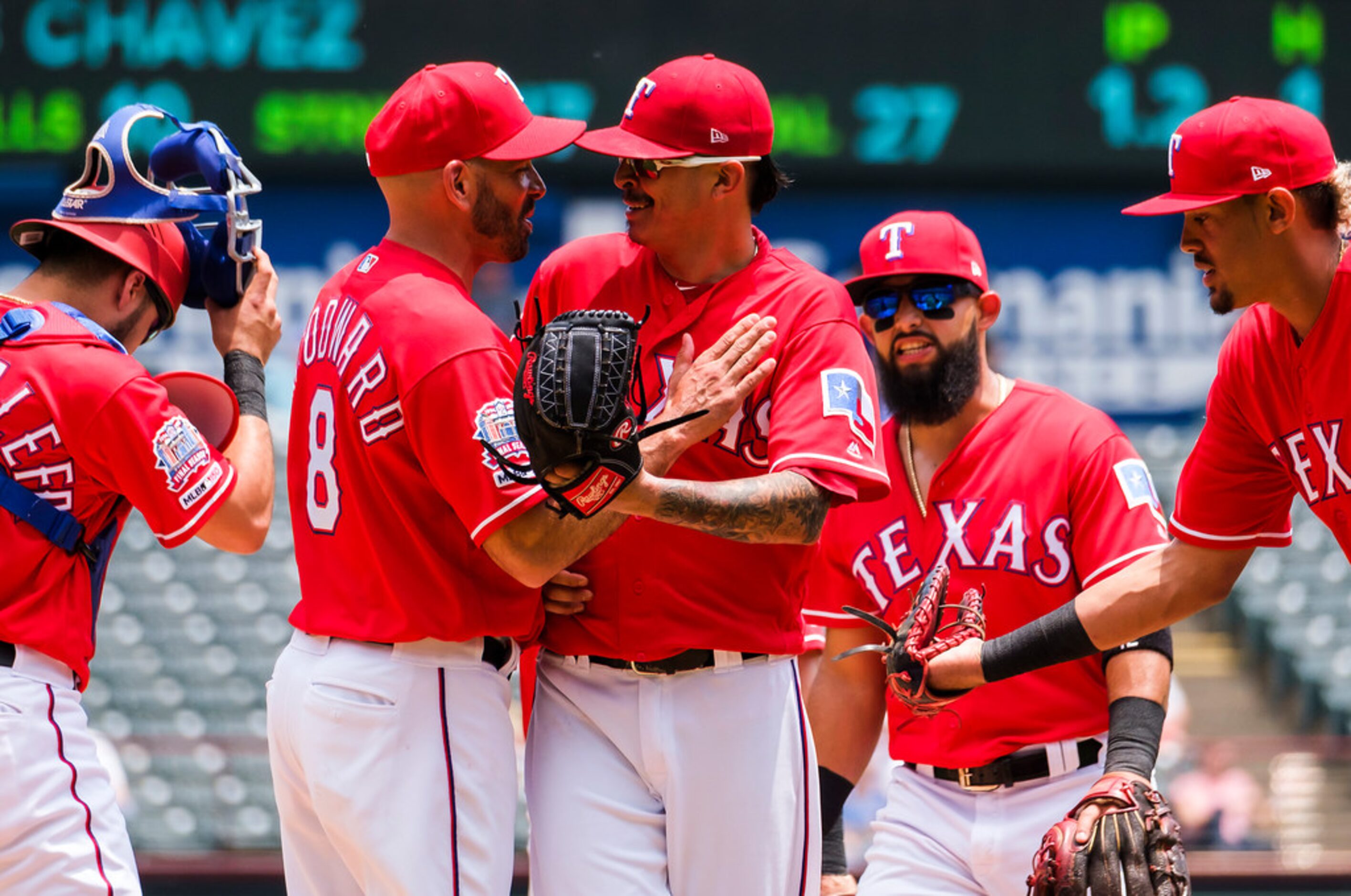 Texas Rangers pitcher Jesse Chavez laughs with manager Chris Woodward as he is lifted from...