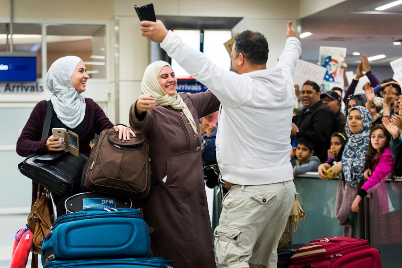 Protestors opposed to President Donald Trump's executive order cheer as Motasim Abusaad of...