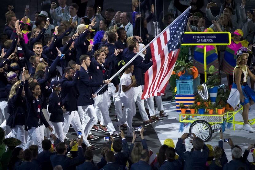 Swimmer Michael Phelps carries the flag as Team USA enters the stadium during the opening...