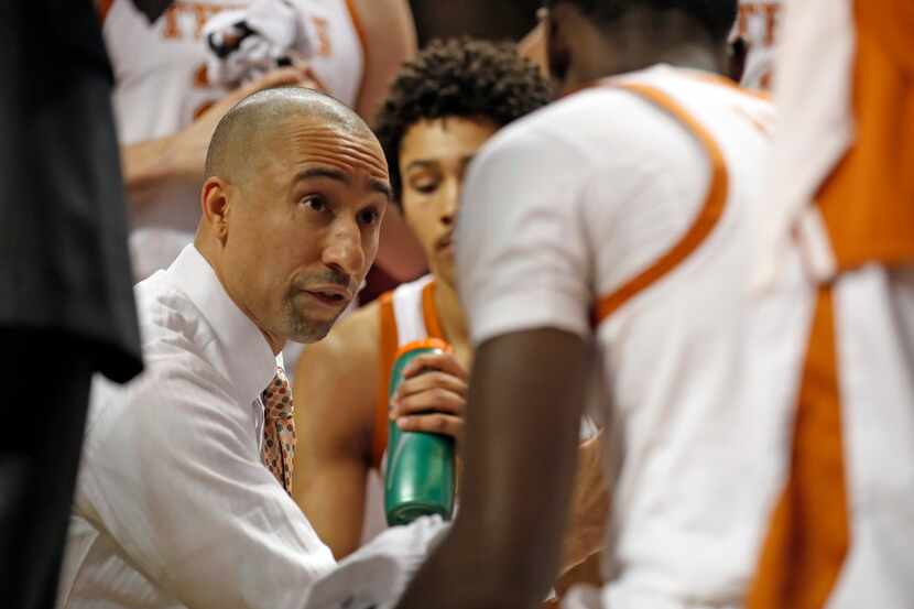 Texas coach Shaka Smart talks to his players on the bench during the first half of an NCAA...