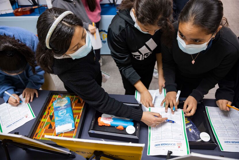 Brianna Rodriguez (right), 11, reads about the Super Soaker invented by Dr. Lonnie George...