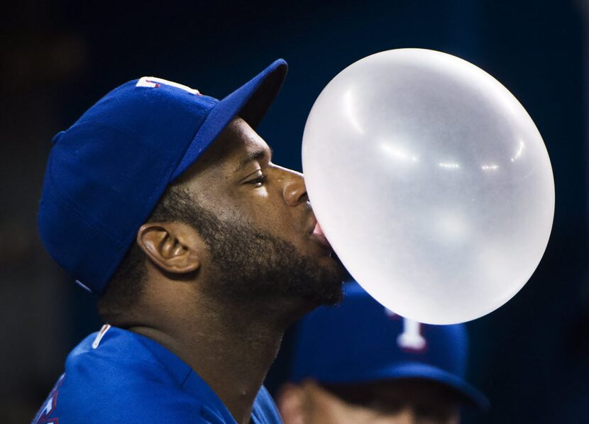 Texas Rangers shortstop Hanser Alberto (2) blows a giant bubble with his bubble gum while...