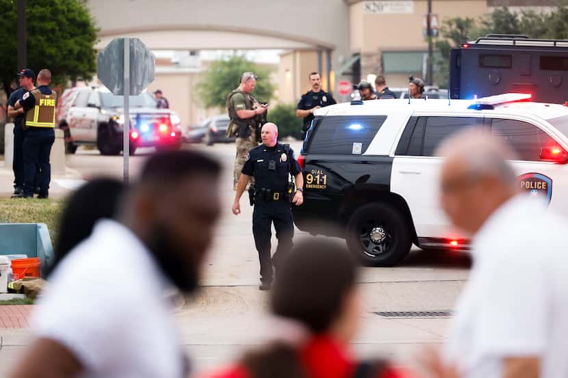 Police gather outside of Allen Premium Outlets mall after a shooting Saturday, May 6, 2023,...