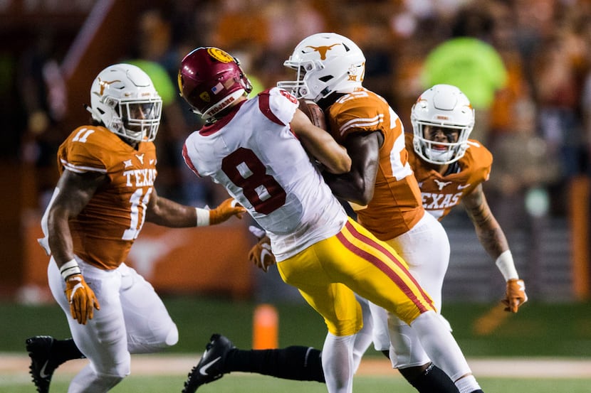 Texas Longhorns defensive back B.J. Foster (25) tackles USC Trojans wide receiver Amon-Ra...